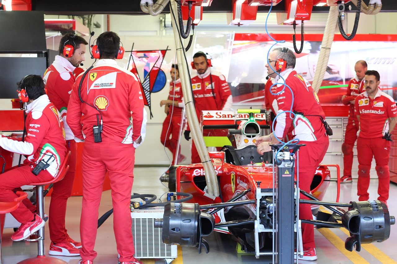 Technicians working around a car in a workshop bay
